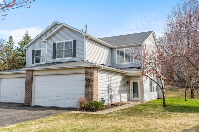 traditional home featuring roof with shingles, a front lawn, a garage, brick siding, and aphalt driveway