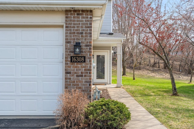 doorway to property featuring a lawn, an attached garage, and stone siding
