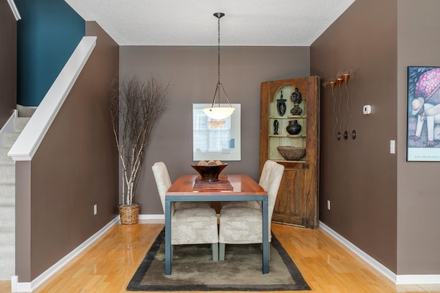 dining space featuring light wood finished floors and baseboards
