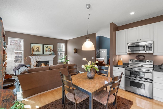 kitchen featuring dark countertops, a wealth of natural light, appliances with stainless steel finishes, and light wood-type flooring