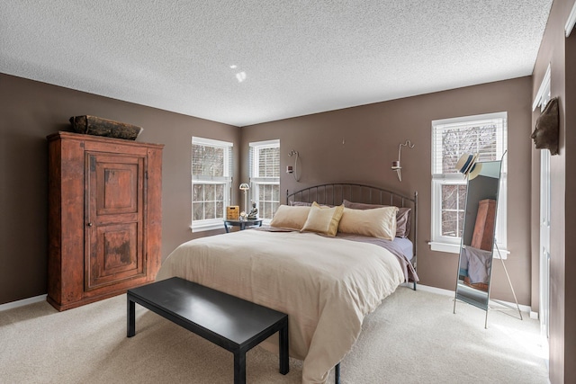 bedroom featuring baseboards, a textured ceiling, and light colored carpet