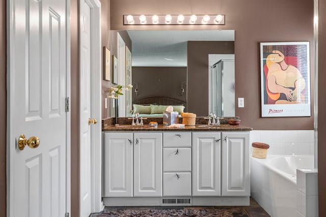 full bath featuring a garden tub, a sink, a shower stall, and double vanity