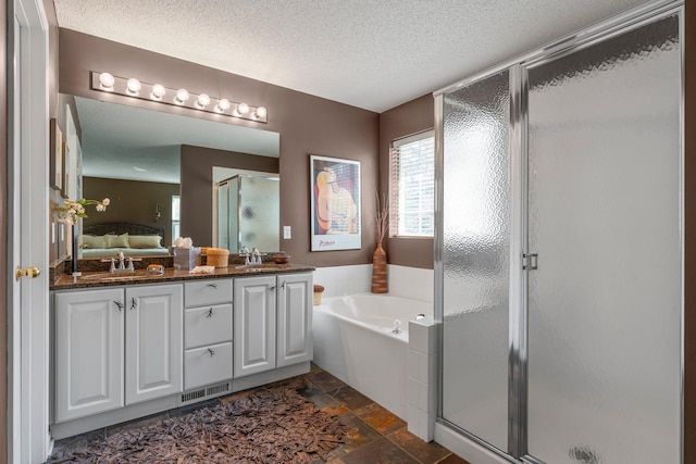 bathroom with a sink, a textured ceiling, a stall shower, ensuite bathroom, and a garden tub