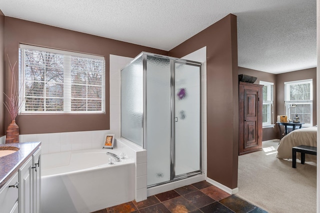 full bathroom with a shower stall, a textured ceiling, a garden tub, and vanity