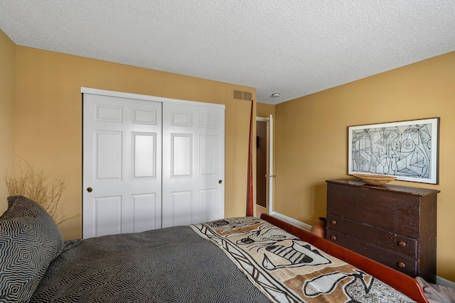 carpeted bedroom featuring a closet, baseboards, visible vents, and a textured ceiling