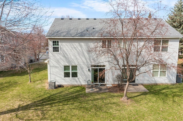 rear view of house with a lawn, roof with shingles, and a patio area
