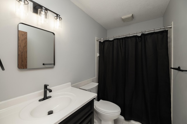 bathroom featuring curtained shower, a textured ceiling, toilet, and vanity