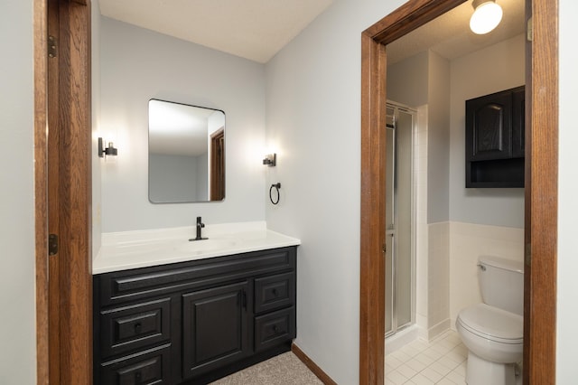 bathroom featuring a shower stall, toilet, vanity, and tile patterned floors