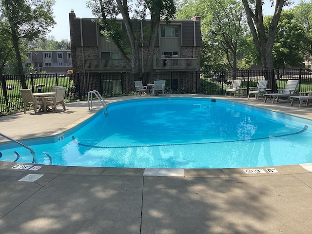 community pool featuring fence and a patio area