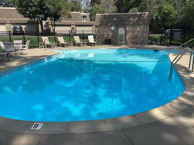 community pool featuring fence and a patio area