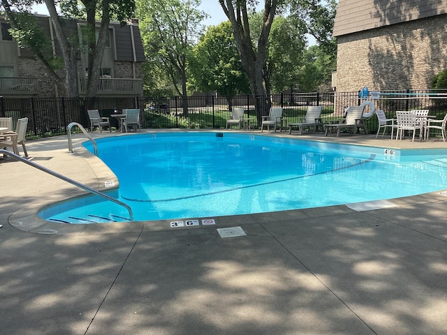 community pool featuring fence and a patio area