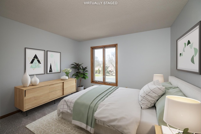 bedroom featuring dark carpet and a textured ceiling