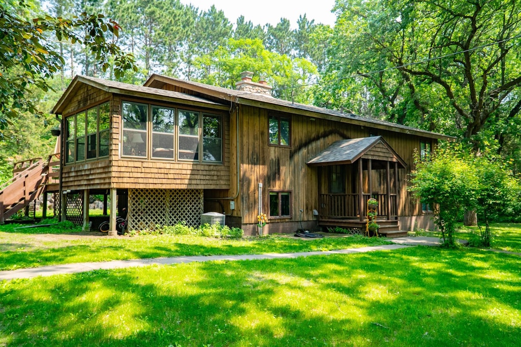16905 211th Ave NW, Big Lake Twp, MN 55309 - view of front of property with a chimney, a front lawn, and a sunroom