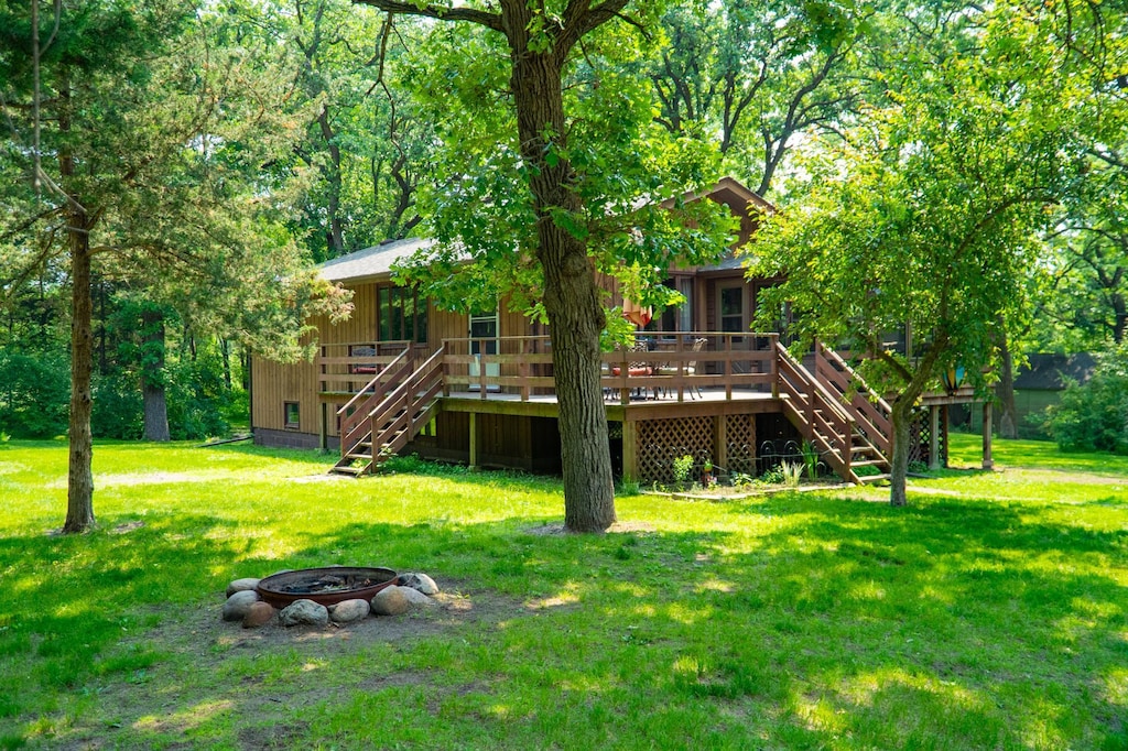16905 211th Ave NW, Big Lake Twp, MN 55309 - rear view of property with stairs, a fire pit, a lawn, and a deck