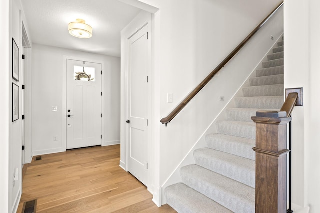4429 Arbor Dr, Woodbury, MN 55129 - foyer entrance featuring light wood-type flooring, stairway, and baseboards