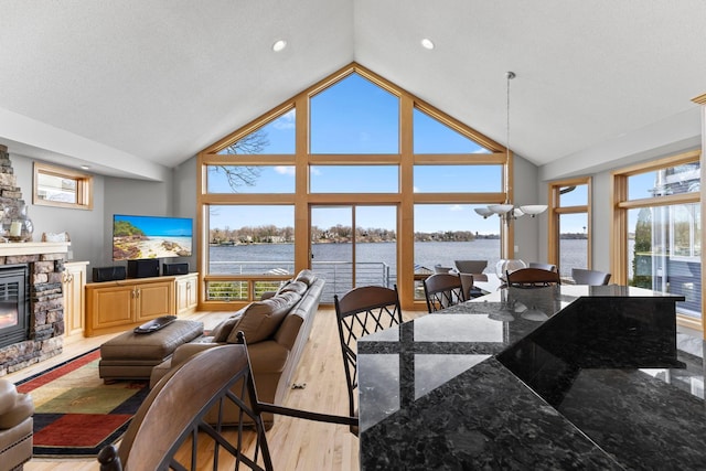4101 Highwood Rd, Orono, MN 55364 - dining area with recessed lighting, high vaulted ceiling, light wood finished floors, and a stone fireplace