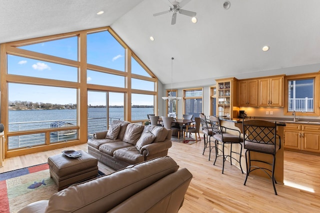4101 Highwood Rd, Orono, MN 55364 - living room featuring high vaulted ceiling, a ceiling fan, a water view, and light wood-style flooring