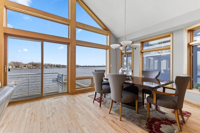 4101 Highwood Rd, Orono, MN 55364 - dining room with an inviting chandelier, a water view, light wood-style floors, and high vaulted ceiling