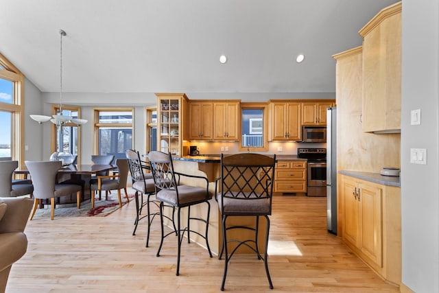 4101 Highwood Rd, Orono, MN 55364 - kitchen featuring a breakfast bar area, appliances with stainless steel finishes, plenty of natural light, and light wood-style flooring