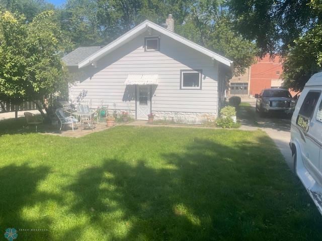 1326 9th Ave S, Fargo, ND 58103 - rear view of house with a yard and a chimney