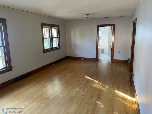 1326 9th Ave S, Fargo, ND 58103 - empty room with visible vents, baseboards, a wealth of natural light, and light wood-style floors