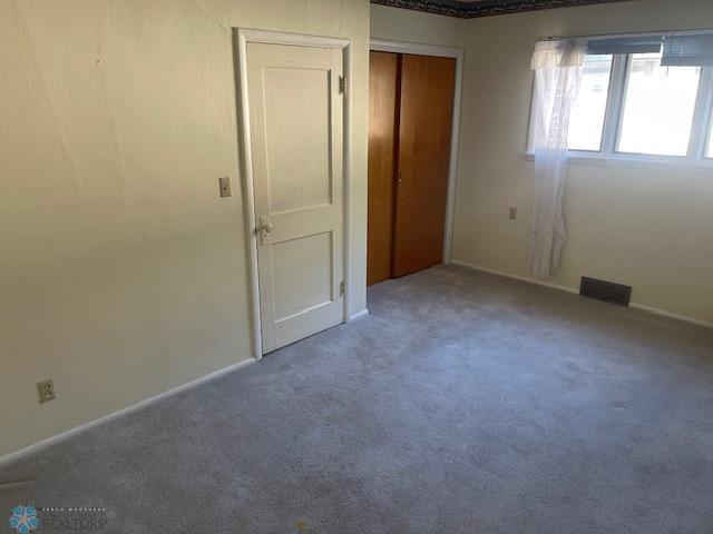 1326 9th Ave S, Fargo, ND 58103 - unfurnished bedroom featuring carpet floors, a closet, visible vents, and baseboards