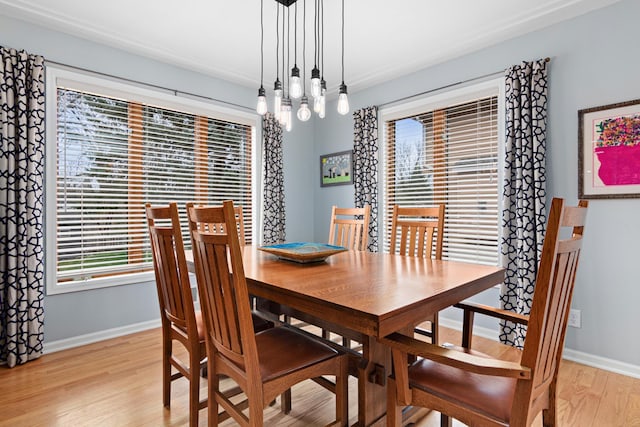 dining space with light wood-style floors, baseboards, and a chandelier