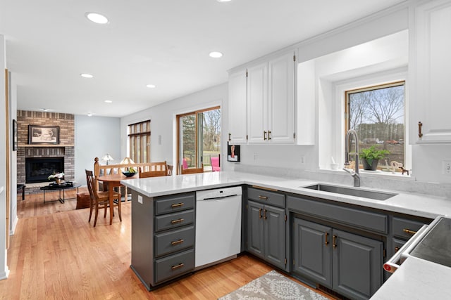 kitchen with a sink, gray cabinetry, white cabinetry, and dishwasher