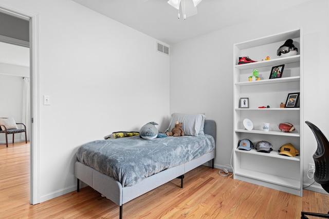 bedroom featuring visible vents, baseboards, and wood finished floors