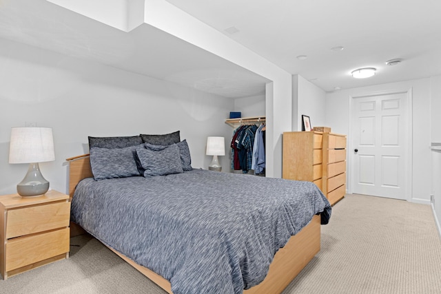bedroom with light carpet, a closet, and a spacious closet