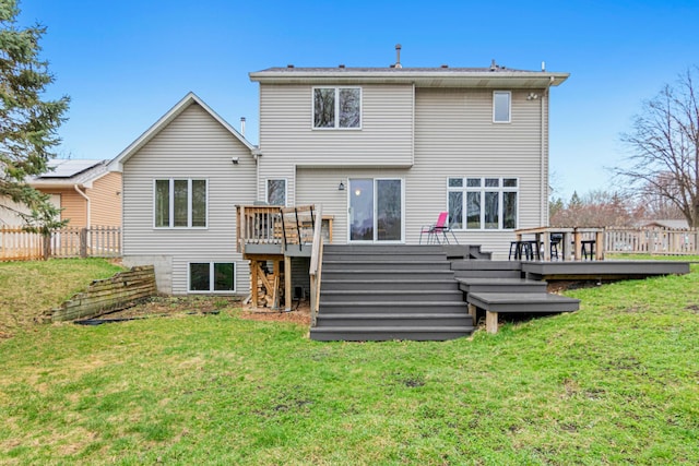 back of property with a lawn, fence, a deck, and stairway
