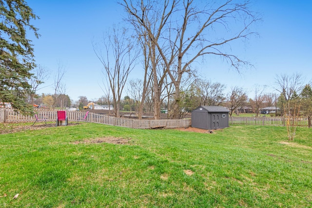 view of yard featuring a fenced backyard, an outbuilding, and a shed