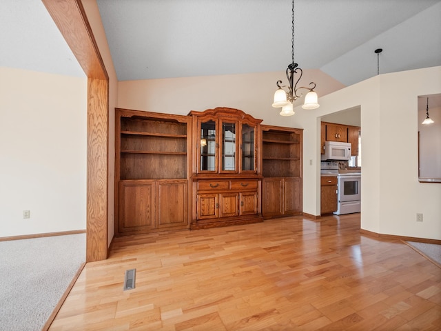 unfurnished dining area with baseboards, lofted ceiling, light wood-style flooring, and a notable chandelier