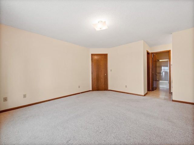 unfurnished room featuring baseboards and light colored carpet