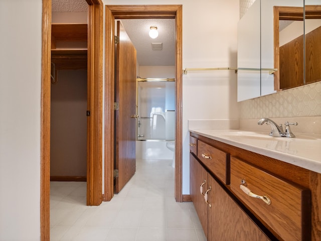 full bathroom featuring backsplash, toilet, vanity, and a textured ceiling