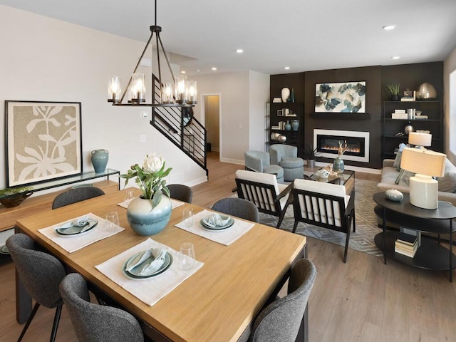 7881 Austin Way, Inver Grove Heights, MN 55077 - dining room with stairway, wood finished floors, a chandelier, a glass covered fireplace, and recessed lighting