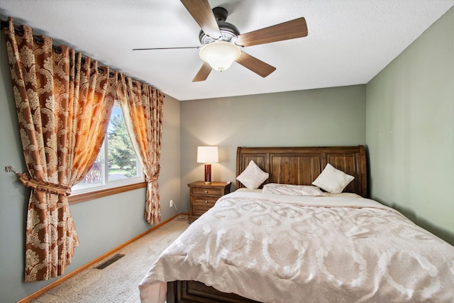 carpeted bedroom with baseboards, visible vents, and ceiling fan