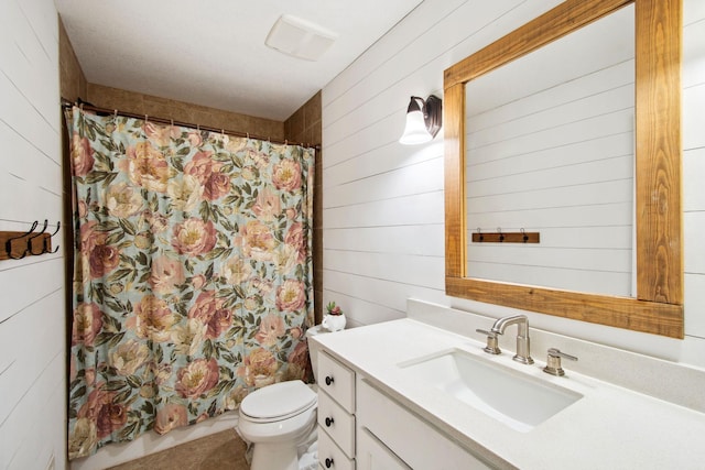 full bath with vanity, wood walls, tile patterned flooring, curtained shower, and toilet