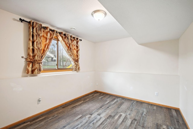 empty room featuring baseboards and wood finished floors