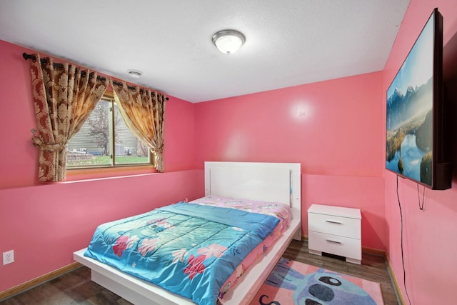 bedroom featuring baseboards and wood finished floors