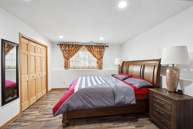 bedroom featuring baseboards, recessed lighting, wood finished floors, and a closet