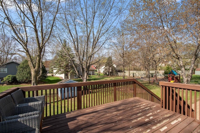 wooden terrace featuring a lawn, a playground, and a residential view