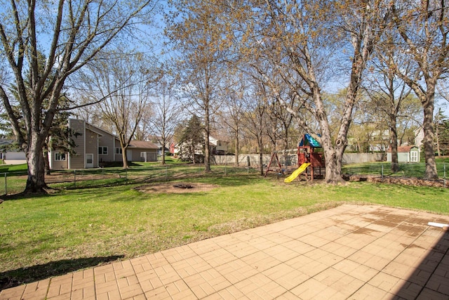 view of yard with a fire pit, a fenced backyard, and a playground