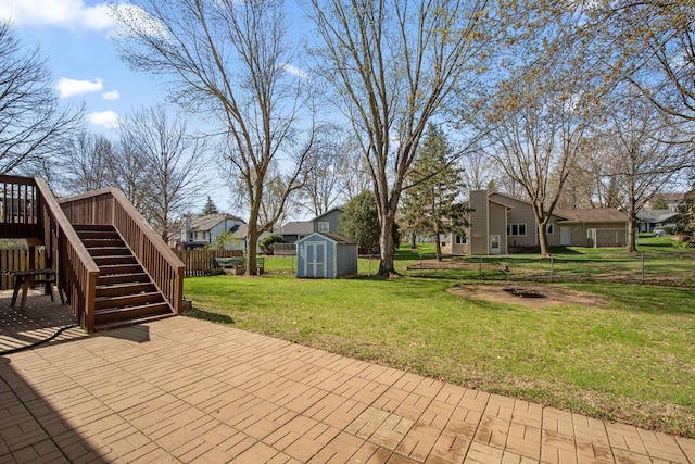 view of patio featuring an outdoor structure, a wooden deck, a fenced backyard, a shed, and stairway