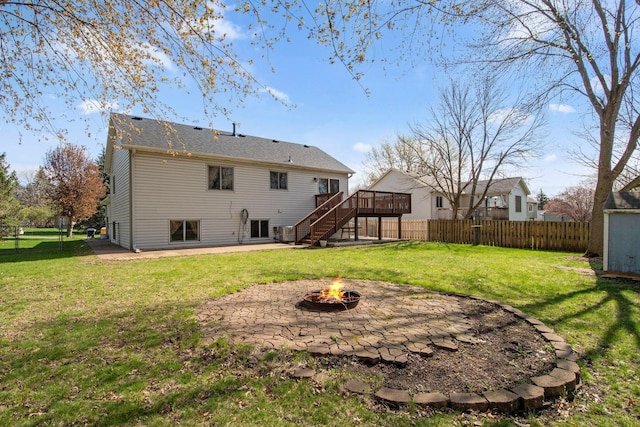 back of property featuring a deck, a patio area, fence, an outdoor fire pit, and stairs