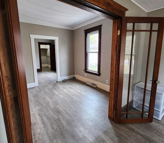 307 11th St NW, Willmar, MN 56201 - empty room featuring crown molding, baseboards, visible vents, and wood finished floors