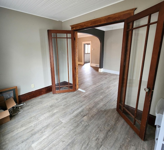 307 11th St NW, Willmar, MN 56201 - spare room featuring baseboards, arched walkways, and wood finished floors