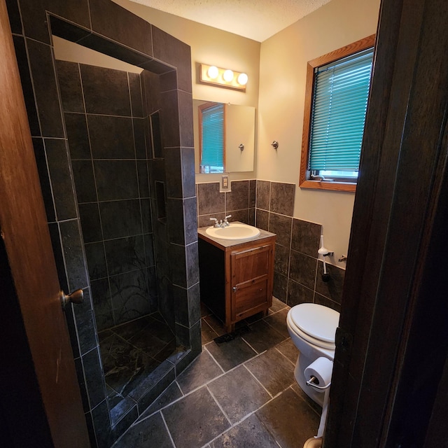307 11th St NW, Willmar, MN 56201 - full bathroom featuring wainscoting, vanity, toilet, tile walls, and tiled shower