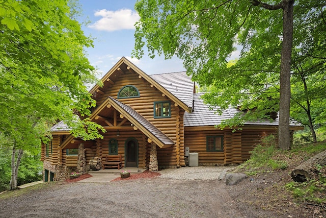 6070 Pilger Ave NW, Annandale, MN 55302 - log cabin featuring log exterior, central air condition unit, a porch, and dirt driveway