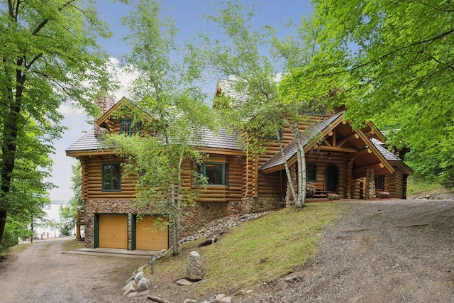 6070 Pilger Ave NW, Annandale, MN 55302 - log-style house featuring a chimney, log exterior, stone siding, and driveway